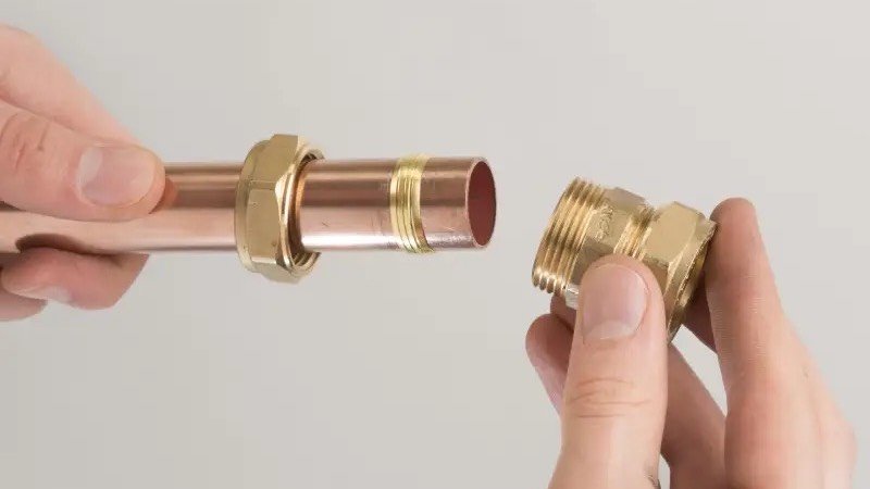 Assemblage d’un raccord en laiton sur un tube de cuivre lors d’une installation sanitaire
